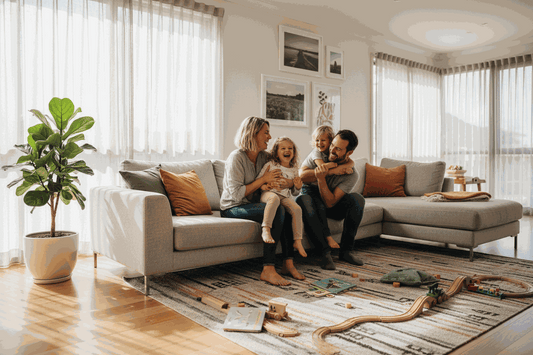 Shared Spaces family living room with parents and children on a beige sectional sofa, toys and books on the rug