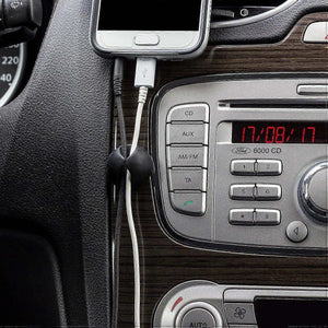 10pcs Black Cable Clamps with smooth black self-adhesive clips holding phone charging cables beside a car stereo