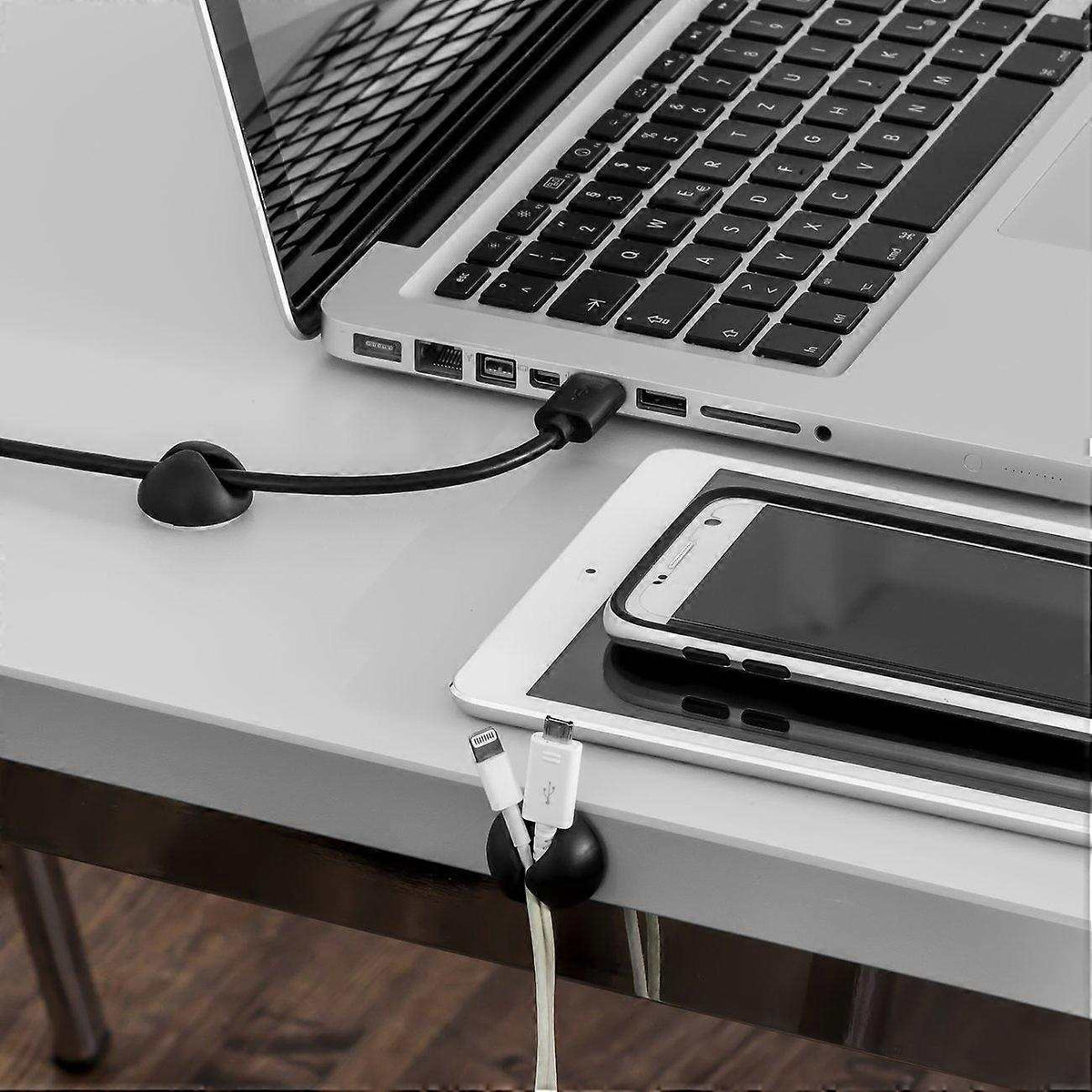 10pcs Black Cable Clamps with rounded black adhesive holders securing charging cables along a desk edge