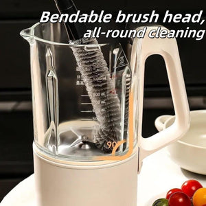 2 in 1 Cleaning Brush with a dark handle and flexible gray bristles cleaning a clear blender jug