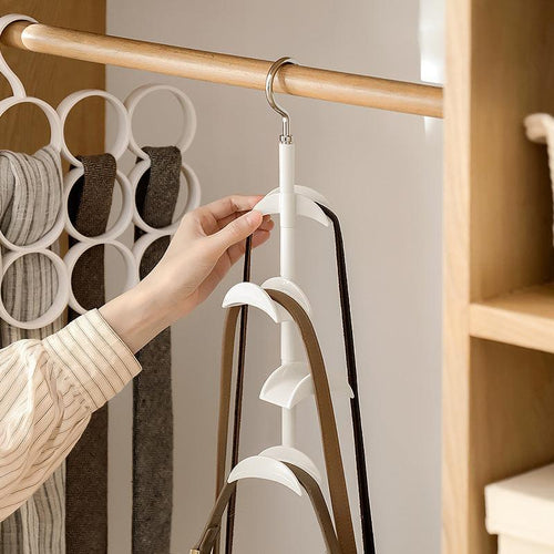 Wardrobe hook rack with white four-tier rotating hooks, curved arms, and metal swivel holding belts inside a closet.