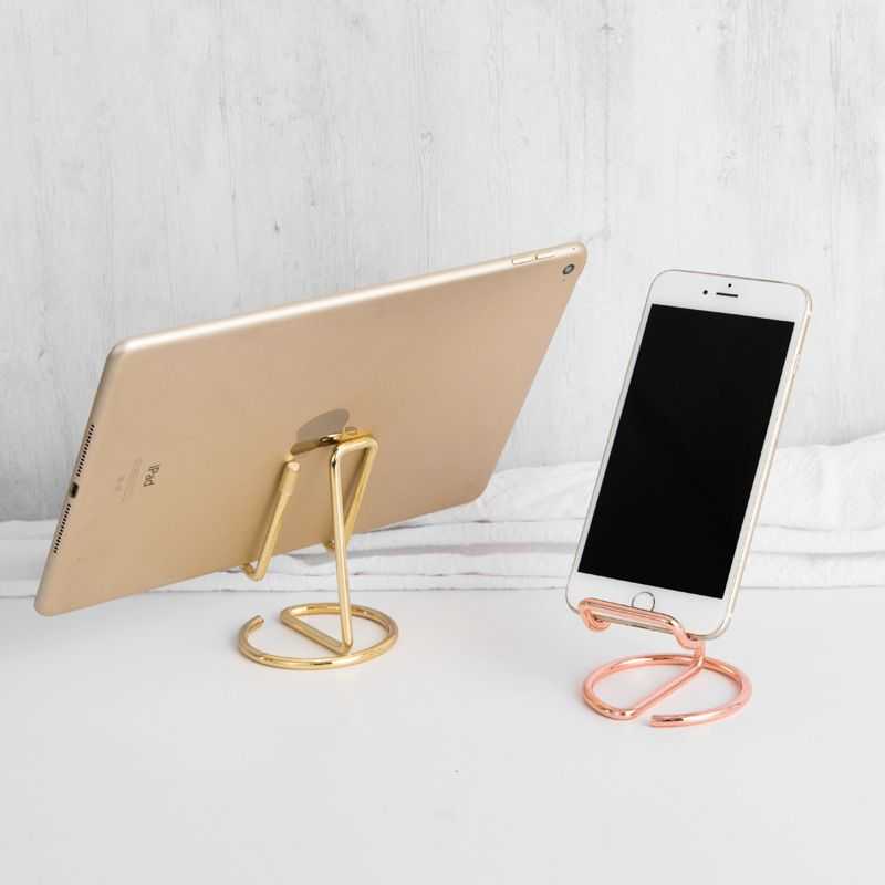 2-Pack Black Universal Aluminum Phone Stand keyword conflicts with the image: two open-frame metal stands in gold and rose gold hold a tablet and phone.