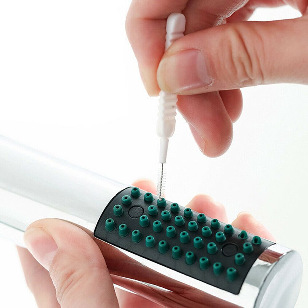 30Pcs Shower Nozzle Cleaning Brush with a white plastic handle and fine metal bristles cleaning a showerhead nozzle