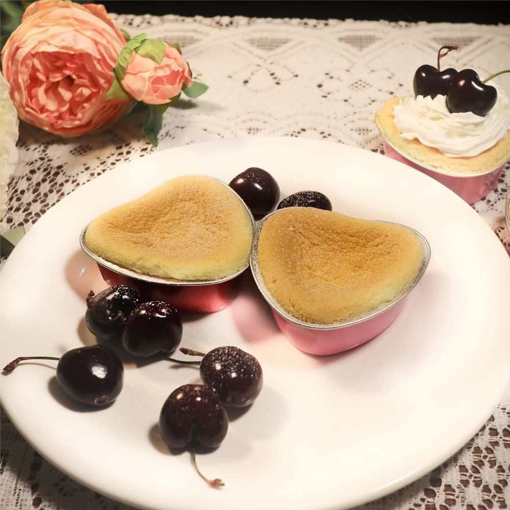 50PCS 3.5oz/100ml Mini Heart Cake Pans with pink sides and silver foil rims, filled with golden heart-shaped cakes
