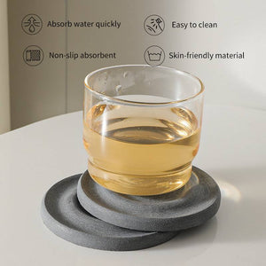 6-Pack Dark Grey Instant Dry round stone coaster set with a layered porous surface and clear glass resting on top
