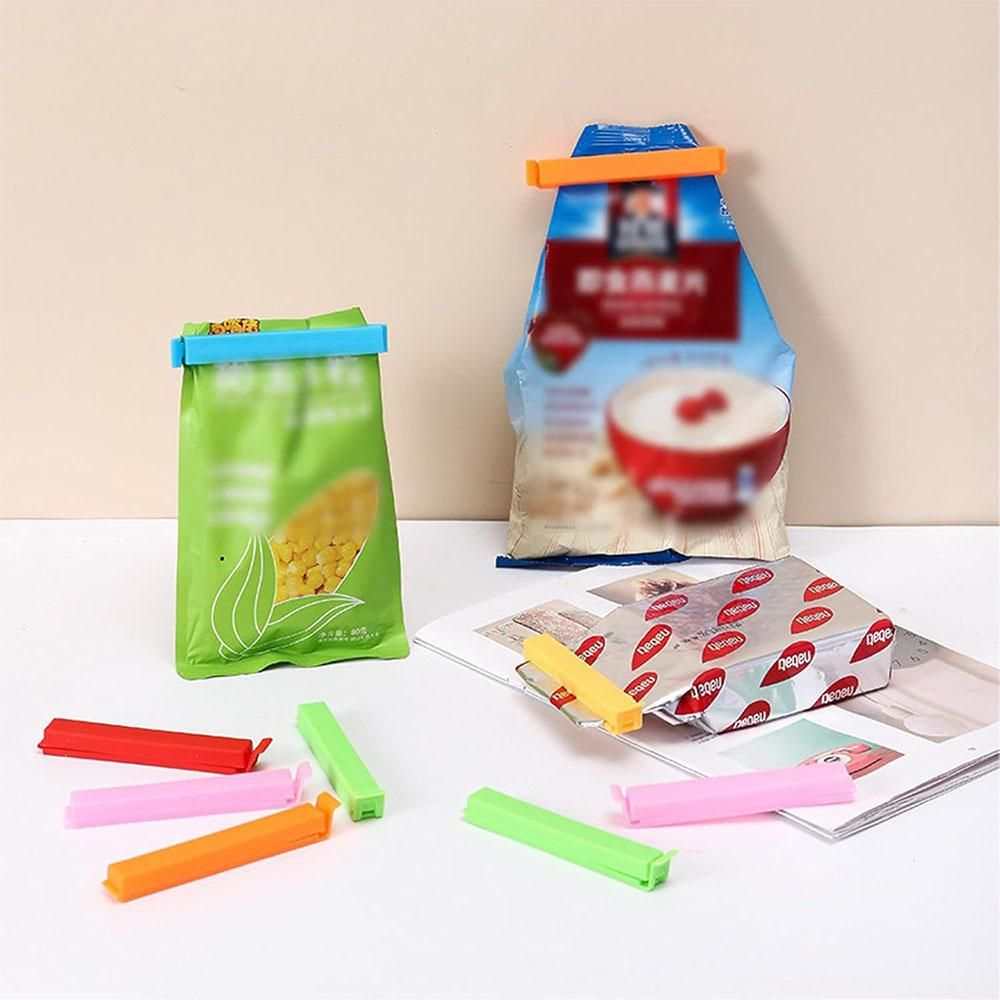 32PCS Food Bag Clips in assorted bright plastic colours, shown sealing snack bags with simple press-close jaws