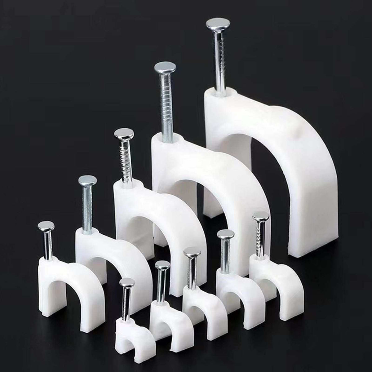 Steel Nail Cable Fixing Clips in white plastic with shiny steel nails, shown in several sizes with arched snap-fit holders