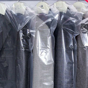 Hanging Garment Bag in clear semi-transparent plastic, covering dark suits and a grey checked jacket with hanger openings