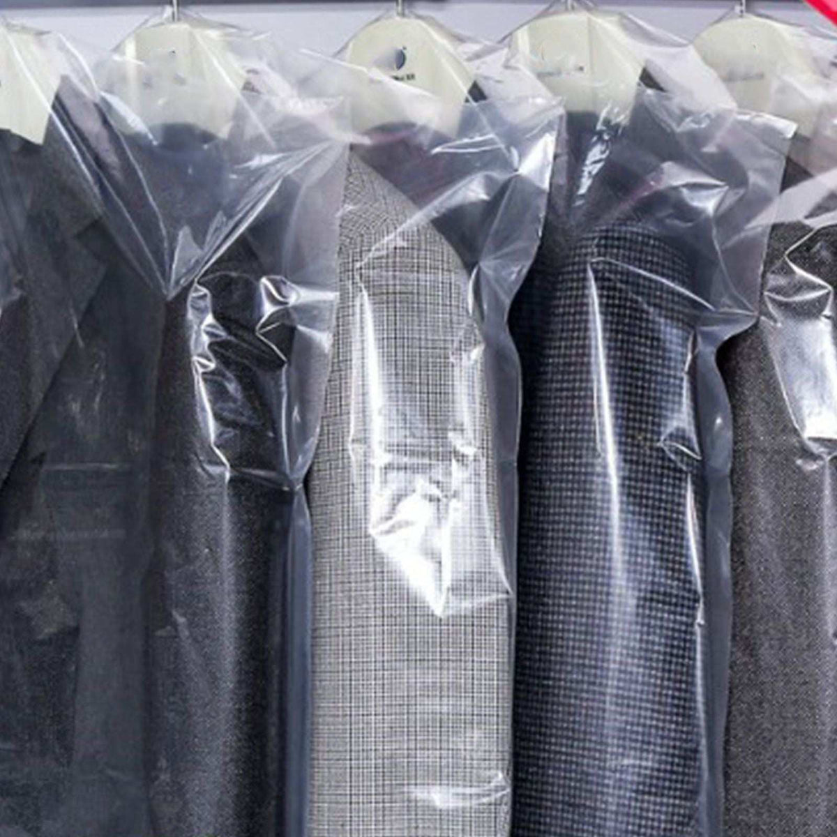 Hanging Garment Bag in clear semi-transparent plastic, covering dark suits and a grey checked jacket with hanger openings