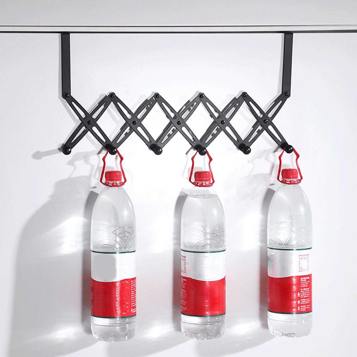 Over Door Hooks rack in black metal with an expandable scissor-style frame and six hooks holding three bottles