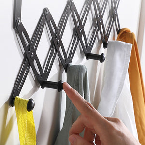Over Door Hooks rack in black metal with an expandable scissor-style frame and rounded hooks holding towels