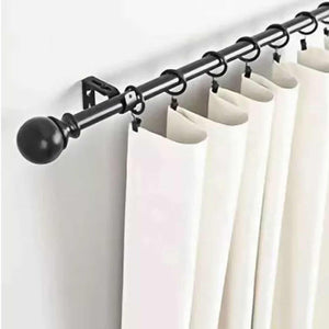 Adjustable Curtain Rod in black iron with a round finial, wall brackets, and rings holding white curtains