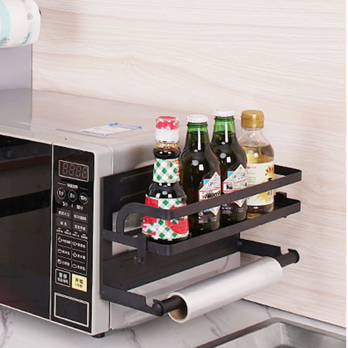 Refrigerator Magnetic Storage Shelf in black metal, featuring two raised rails and a lower paper towel holder, with bottles stored on top