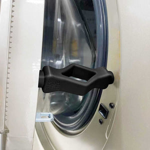 Front Load Washer Door Prop in black molded plastic with a wide handle shape, holding a washing machine door ajar