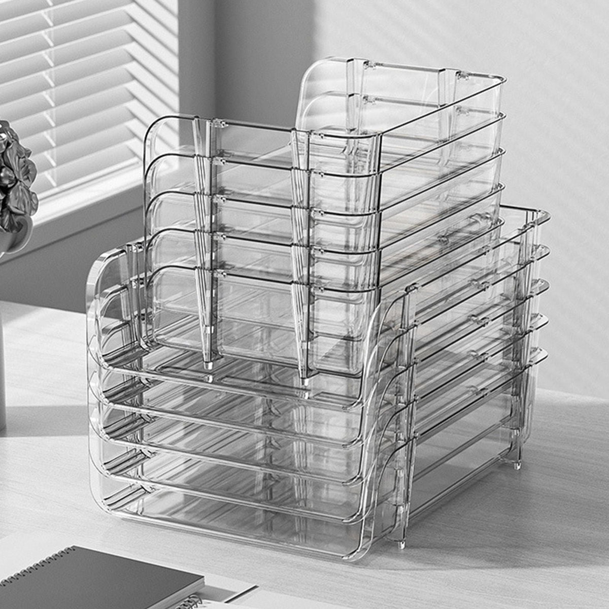 Transparent Desktop Stationery Organizer made of clear plastic, with open stepped compartments and stackable, ridged trays
