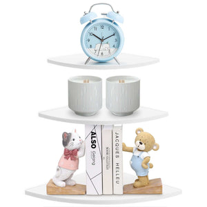 Floating Corner Shelf in white PVC with three rounded triangular tiers displaying a clock, planters, books and figurines