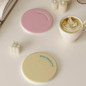 2 Pcs Blue Quick-Dry diatom mud coasters shown as smooth round pastel pink and pale yellow cup mats.