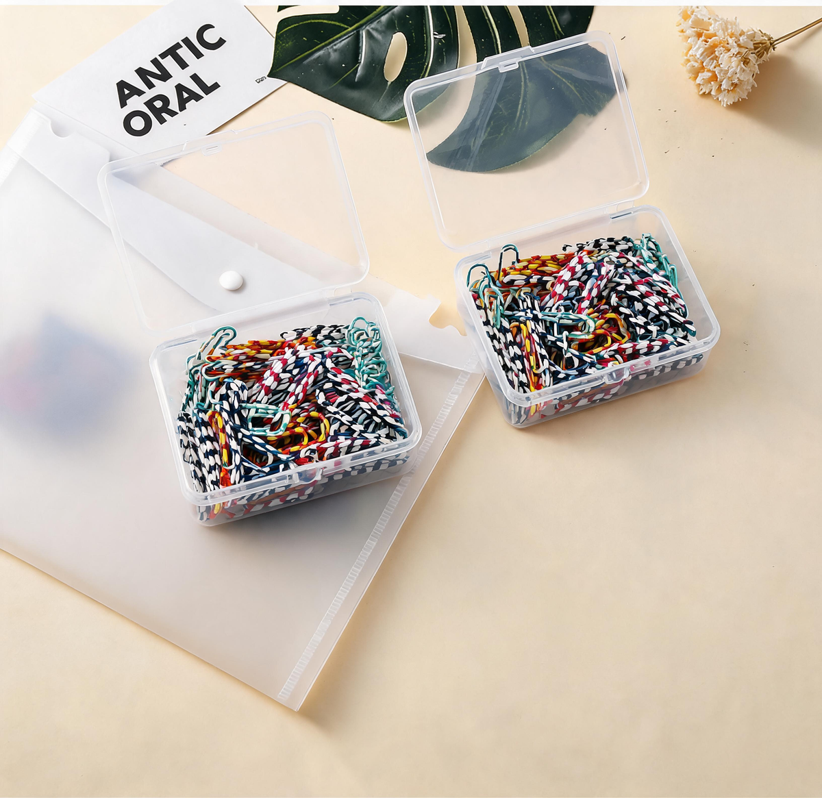 A4 Snap-Closure File Pouch in clear plastic with a white snap button, shown beside boxes of multicoloured patterned paper clips