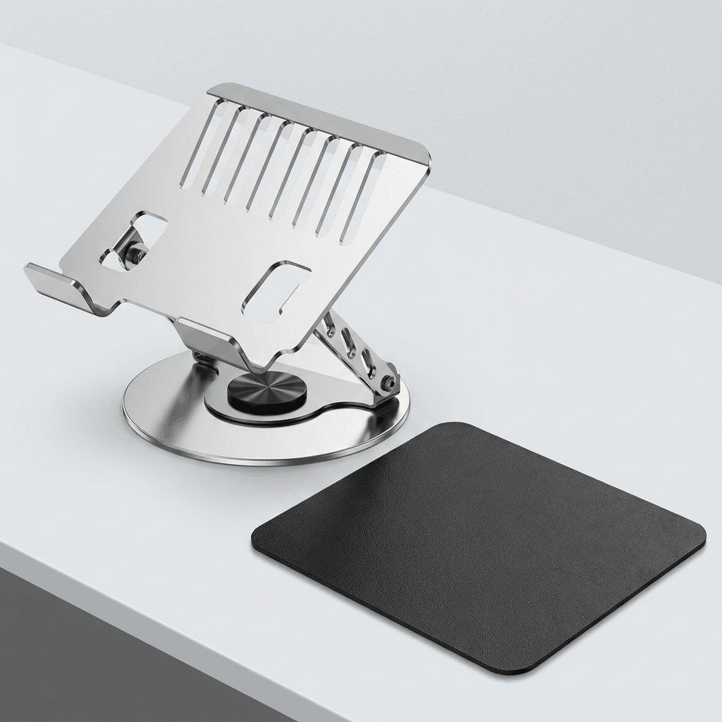 Adjustable aluminum alloy laptop stand in polished silver metal with an open slotted tray and round rotating base, paired with a black mouse pad