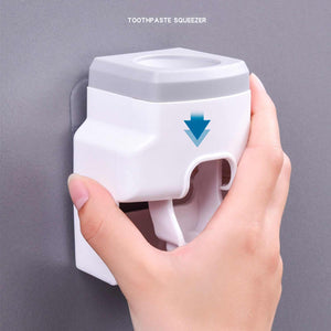 Automatic Toothpaste Dispenser in white and light grey ABS plastic, with a front dispensing lever and toothpaste tube opening