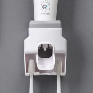 Automatic Toothpaste Dispenser in white and grey plastic with an inverted tube mount and two toothbrush slots