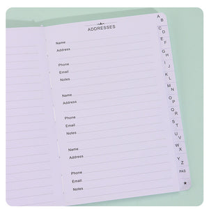 Black Address Book open to lined contact pages with A–Z alphabetical index tabs and dedicated address fields