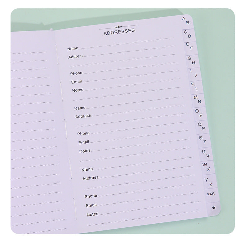 Black Address Book open to lined contact pages with A–Z alphabetical index tabs and dedicated address fields