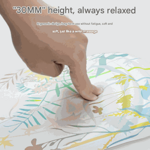 Mouse pad with Black Flower Pattern in pale botanical colors and a raised silicone gel wrist rest pressed by a finger