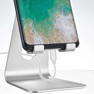 Black Foldable Aluminum Alloy phone stand shown supporting a smartphone, with a hinged frame and charging cable access
