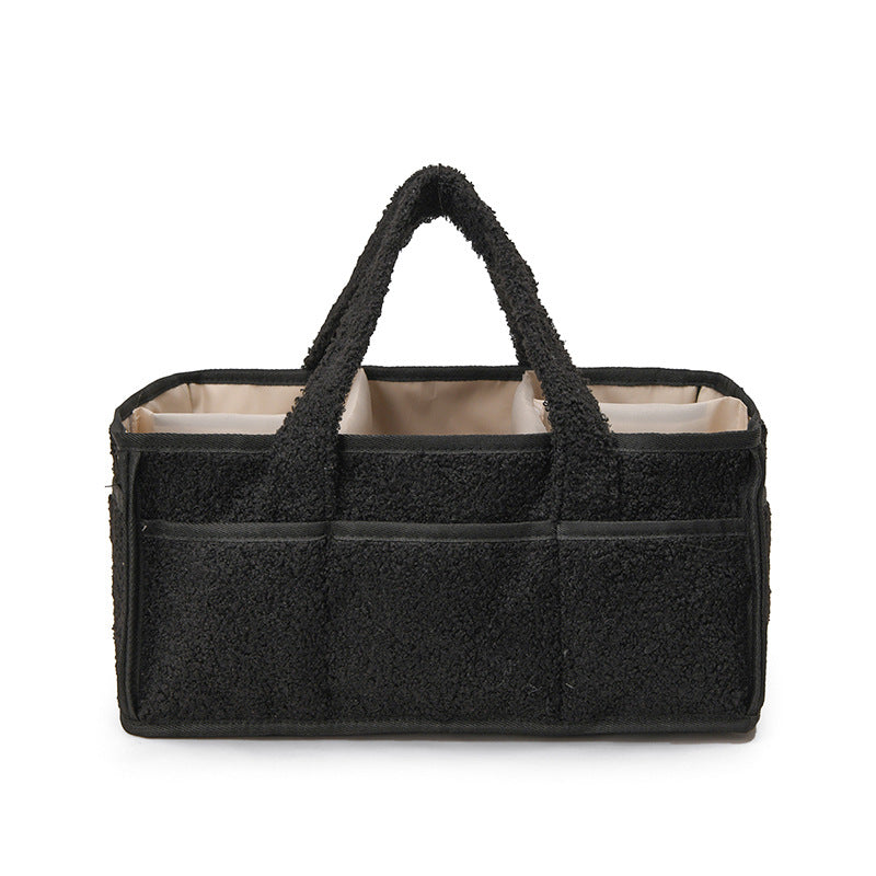 Black Large Plush Nappy Caddy with soft black exterior, beige lining, front pockets and two sturdy carry handles