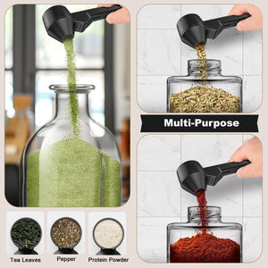 Black Sliding Coffee Scoop with long handle measuring green powder, tea leaves, pepper and red powder in jars