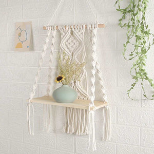 Boho Macrame Wall Hanging Shelf in cream cotton rope with intricate knotted weaving and a pale wood shelf