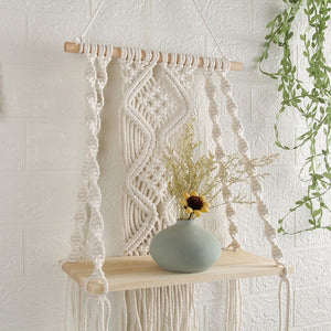 Boho Macrame Wall Hanging Shelf in cream cotton rope with intricate knotted patterns and a light wood shelf