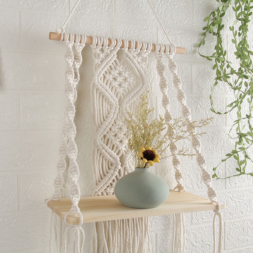 Boho Macrame Wall Hanging Shelf in cream cotton rope with intricate knotted patterns and a light wood shelf
