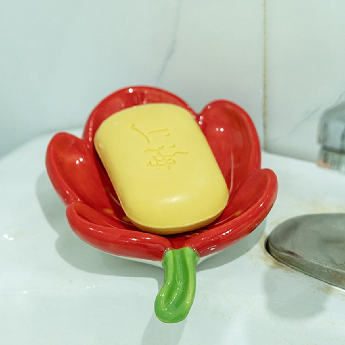 Ceramic Leaf Soap Box in glossy red leaf-shaped ceramic with a green stem, holding a yellow bar of soap