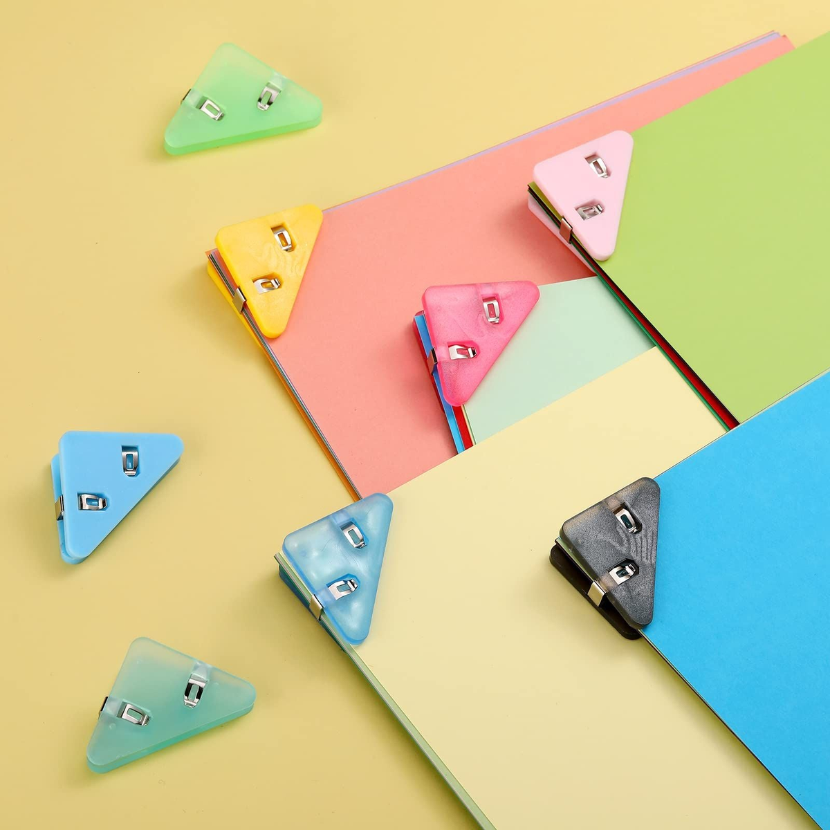 Corner Clip Triangle page clips in assorted translucent and solid colours, with triangular plastic bodies and metal grips