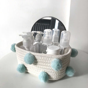 Cotton Rope Knitting storage basket in cream woven cotton rope, decorated with pale blue fluffy pom-poms
