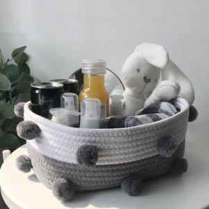Cotton Rope Knitting storage basket in grey and white woven cotton rope, decorated with dark grey fluffy pom-poms