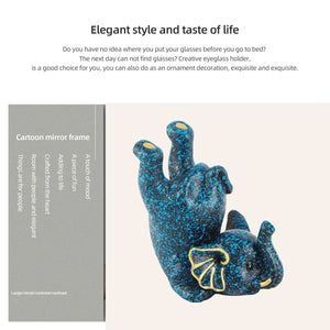 Creative Attraction Small Elephant glasses holder in black resin with bright blue speckles and yellow accents, sculpted as a reclining elephant