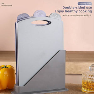 Double-Sided Antibacterial Kitchen Chopping Board Set with three light grey boards, food-icon tabs, and a matching storage stand