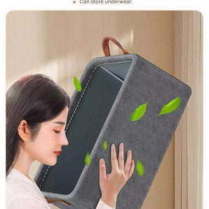 Foldable Fabric Storage Bin in grey fabric with green leaf accents, structured frame, contrasting dark interior and handle