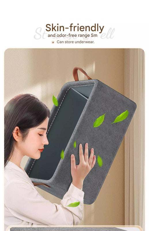 Foldable Fabric Storage Bin in grey fabric with green leaf accents, structured frame, contrasting dark interior and handle