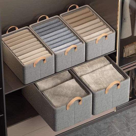 Foldable Fabric Storage Bin in grey woven fabric with tan handles, holding neatly arranged clothing in closet shelving