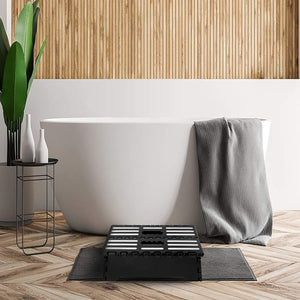 Folding Step Stool in black plastic with a textured anti-slip top, raised white grip strips and a carry handle
