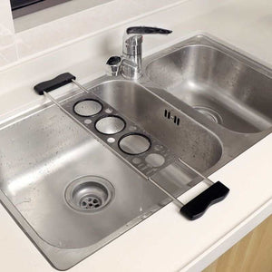 Heavy-Duty Stainless Steel Kitchen sink drying rack in grey metal with black end grips and circular drainage openings