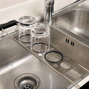 Heavy-Duty Stainless Steel Kitchen sink caddy in silver metal with drainage holes and black sponge holder rings