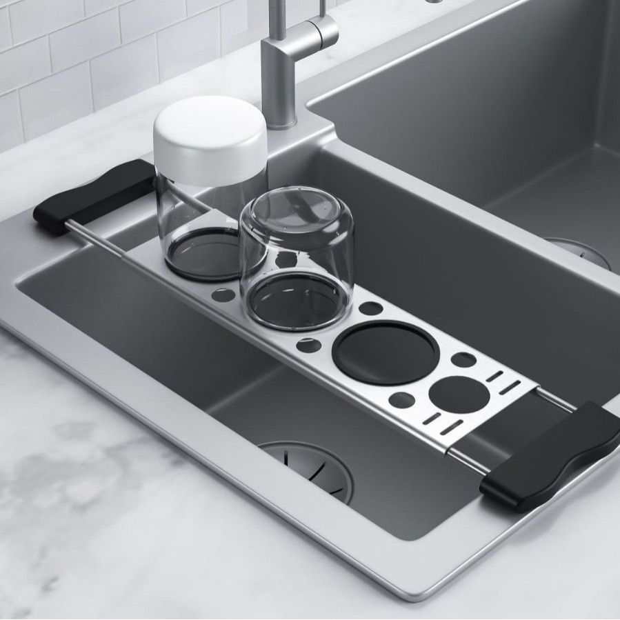 Heavy-Duty Stainless Steel Kitchen sink drying rack in silver metal with black end grips and circular drainage openings