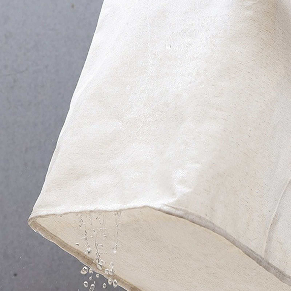 Laundry Basket Waterproof in natural cream cotton-linen fabric, shown close up with water droplets beading on its surface.