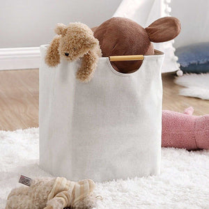 Laundry Basket Waterproof hamper in natural cream fabric with a wooden handle, holding plush toys and soft linens