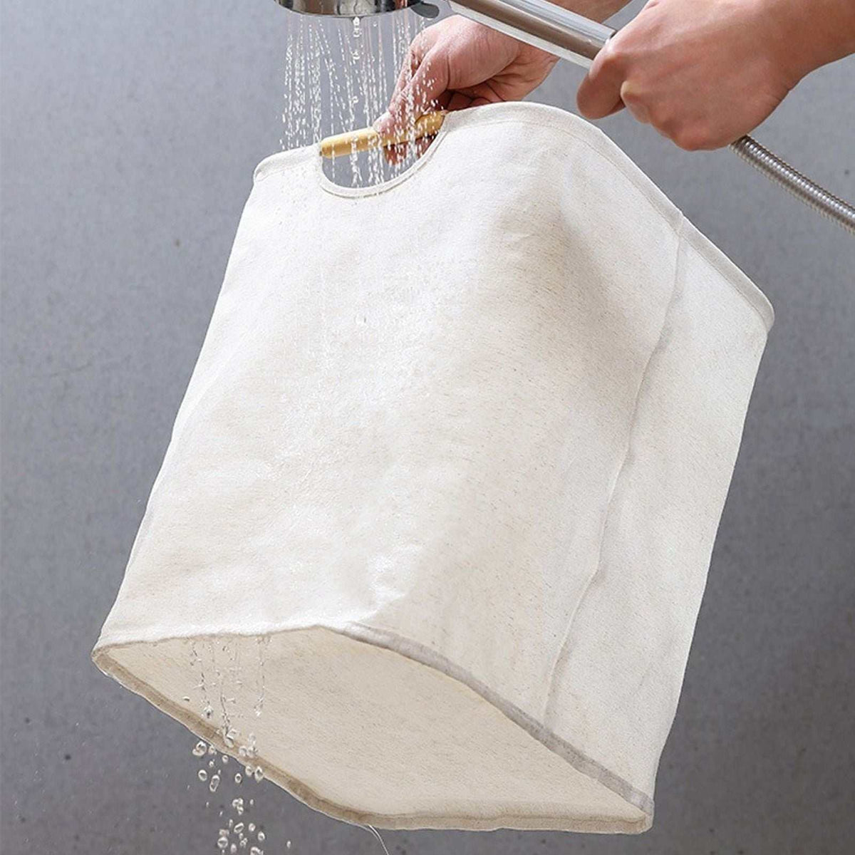 Laundry Basket Waterproof in off-white fabric, shown with water pouring through its soft, collapsible body